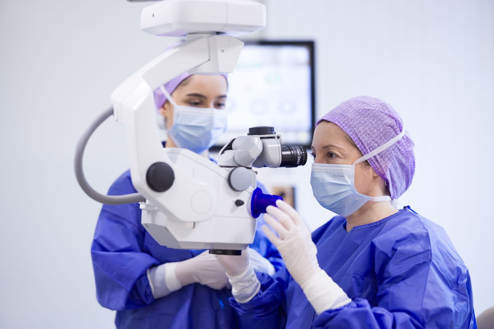 Two eye surgeons during an operation at the operating microscope